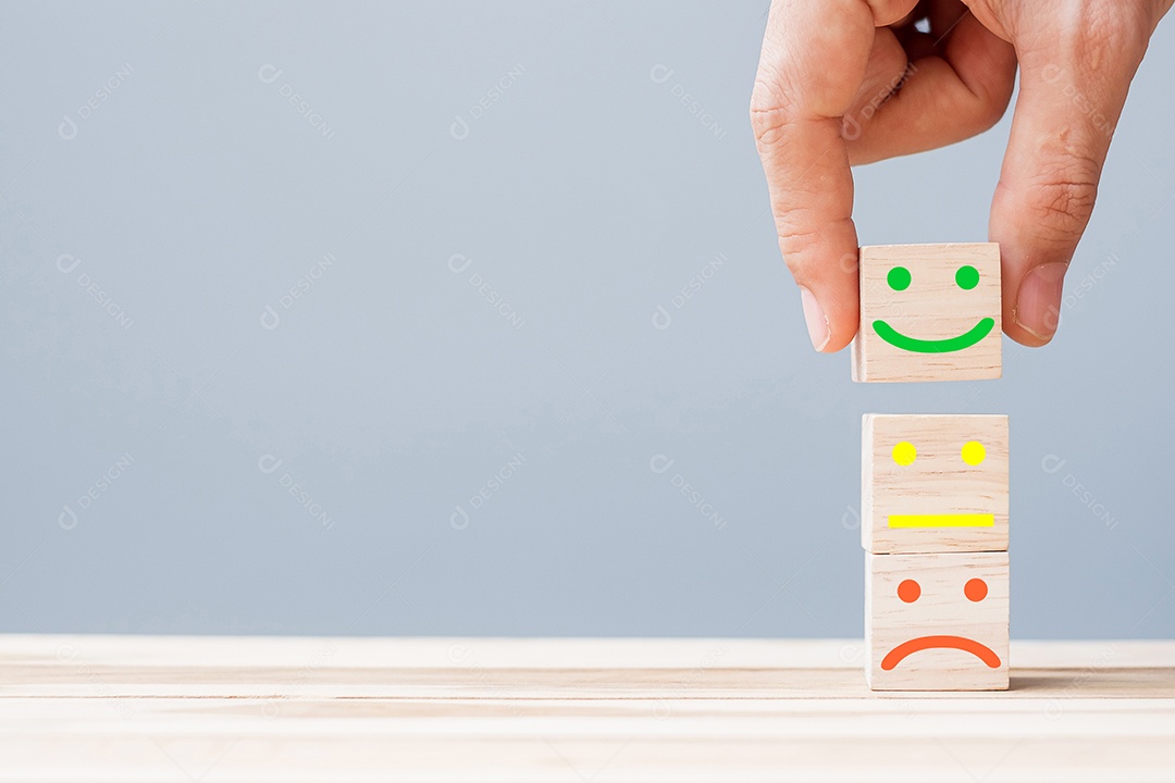 Mão segurando blocos de cubo de madeira de símbolo de rosto de emoção. Rato de serviço