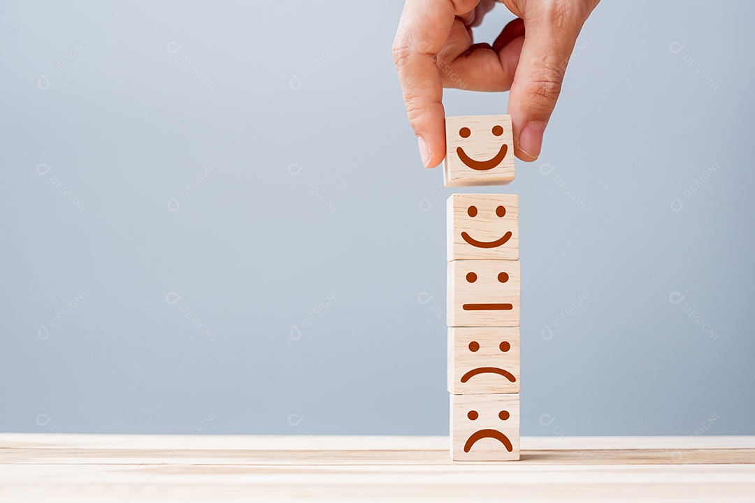 Mão segurando blocos de cubo de madeira de símbolo de rosto de emoção. Rato de serviço