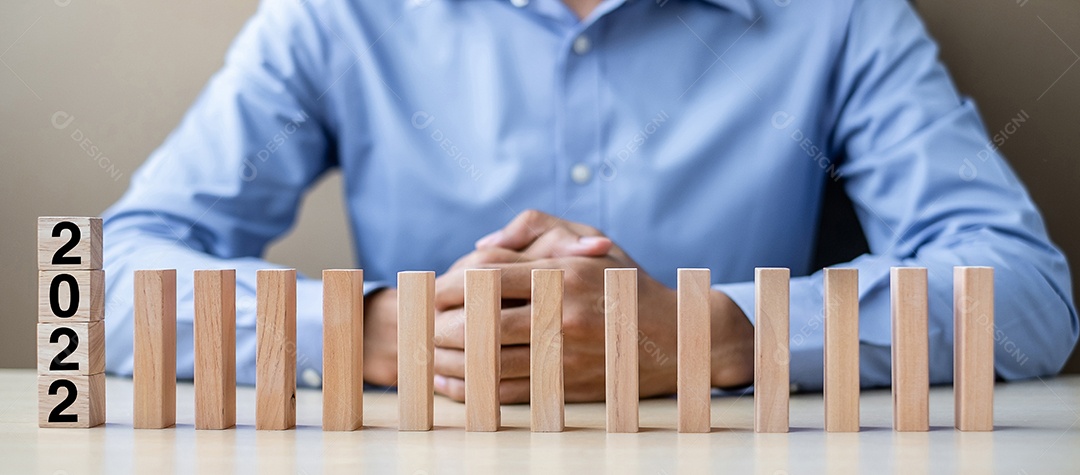 Empresário com 2022 blocos de madeira. Negócios, Gestão de Riscos, Seguros, Resolução, estratégia, solução, objetivo, Ano Novo Novo Você e conceitos de boas festas