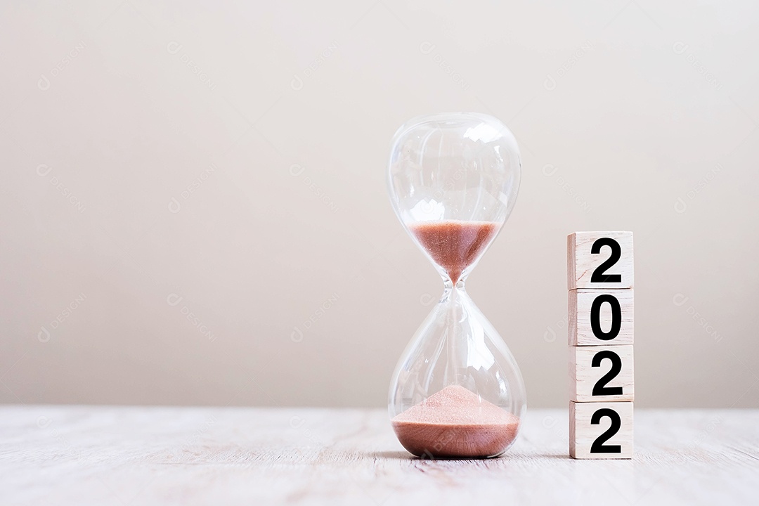 Ampulheta com 2022 blocos de cubos de madeira na mesa, areia fluindo através do bulbo de Sandglass medindo o tempo de passagem. contagem regressiva, prazo, feliz ano novo, resolução e novo conceito de início