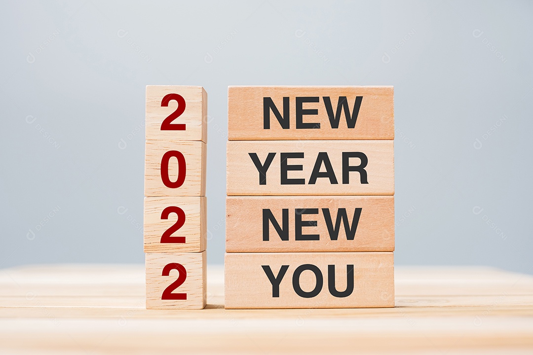 Mão de empresário segurando bloco de madeira com texto 2022 ANO NOVO.