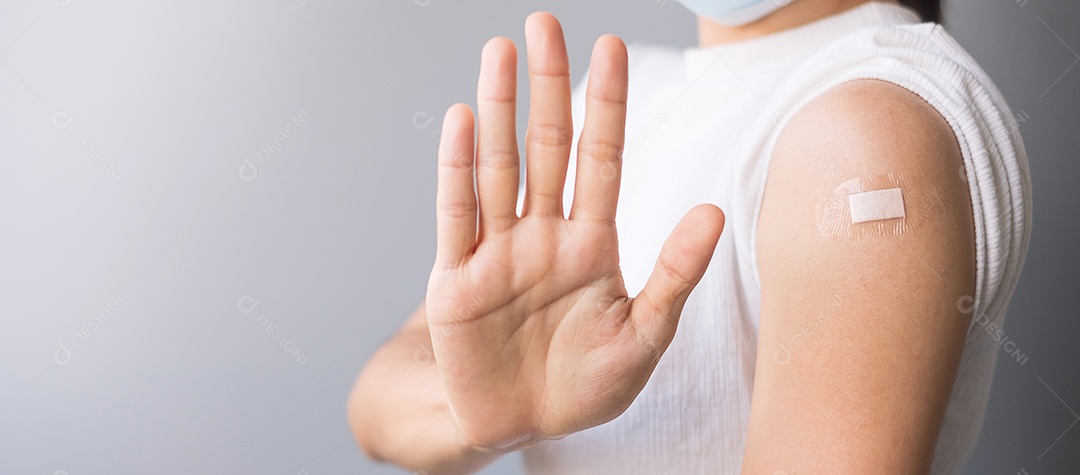 Mulher mostrando o braço com curativo e dando sinal de parada na popa