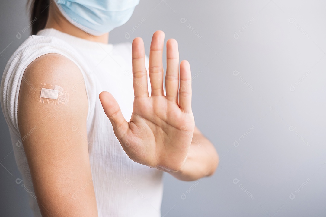 Mulher feliz mostrando o braço com curativo após receber a vacina