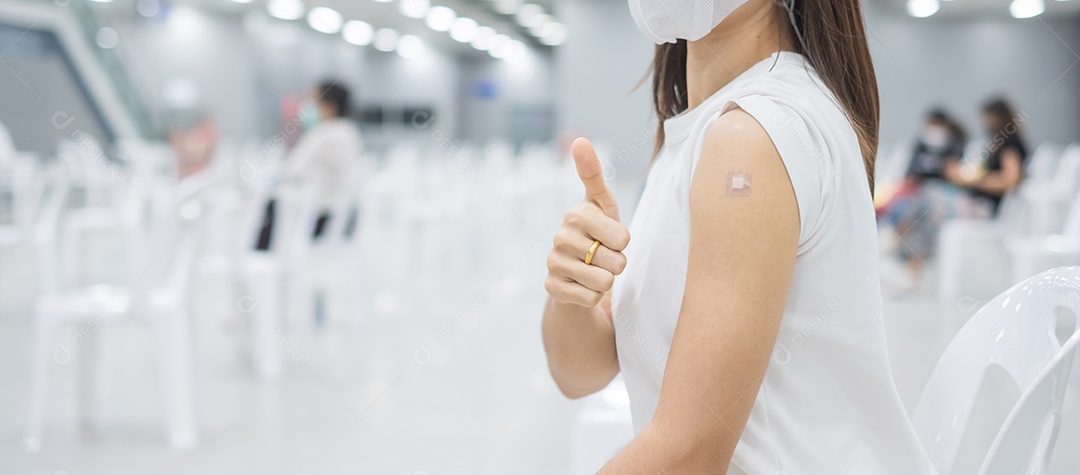 Mulher feliz mostrando o polegar depois de receber a vacina. Vacinação,