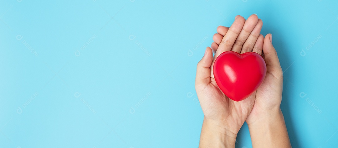 Woman holding red heart shape on blue background