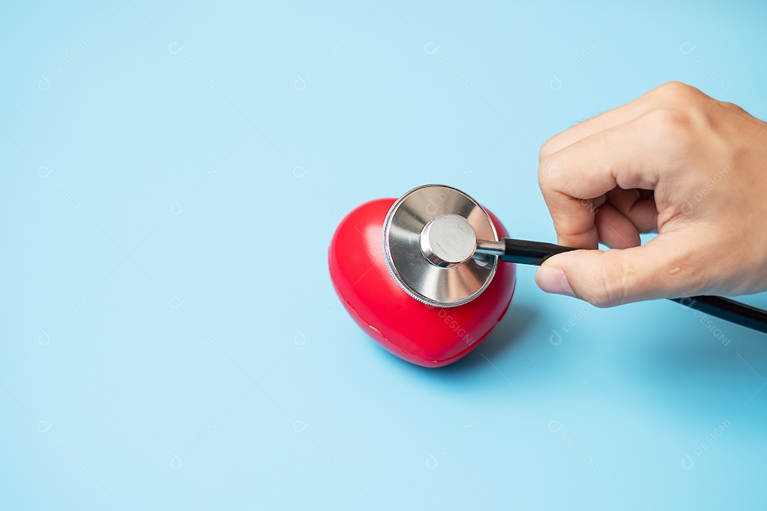 Mão de médico segurando estetoscópio com forma de coração vermelho em azul