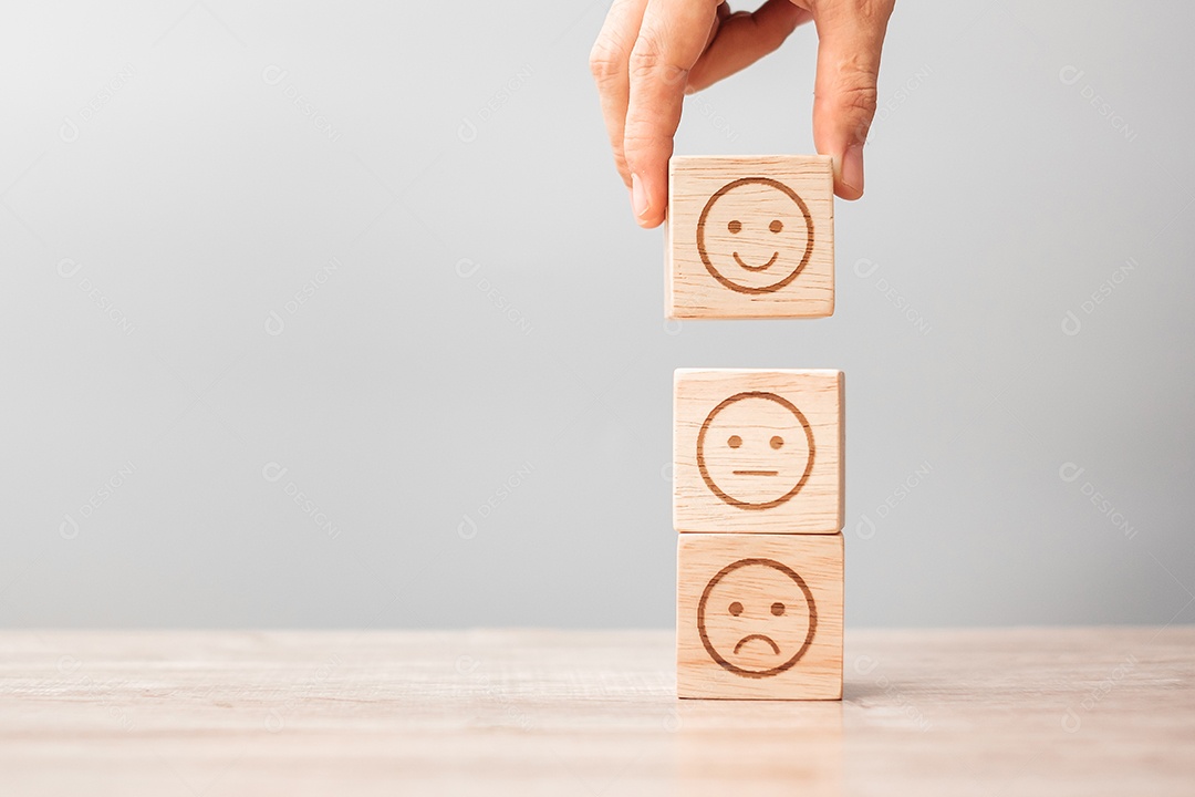 Mão de homem segurando o bloco de rosto de emoção. Cliente escolhe Emoticon