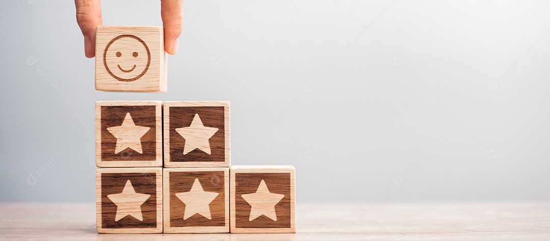 mão segurando o rosto de sorriso sobre blocos de símbolo de estrela na mesa background