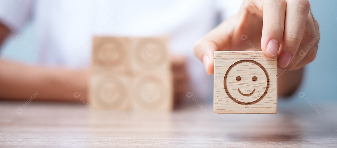 Mão de homem segurando o bloco de rosto de emoção. Cliente escolhe Emoticon