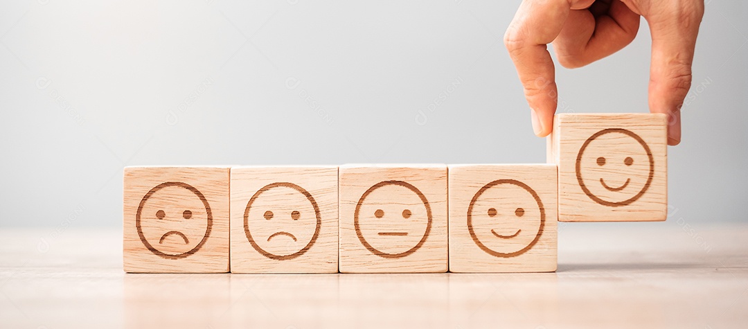 Mão de homem segurando o bloco de rosto de emoção. Cliente escolhe Emoticon