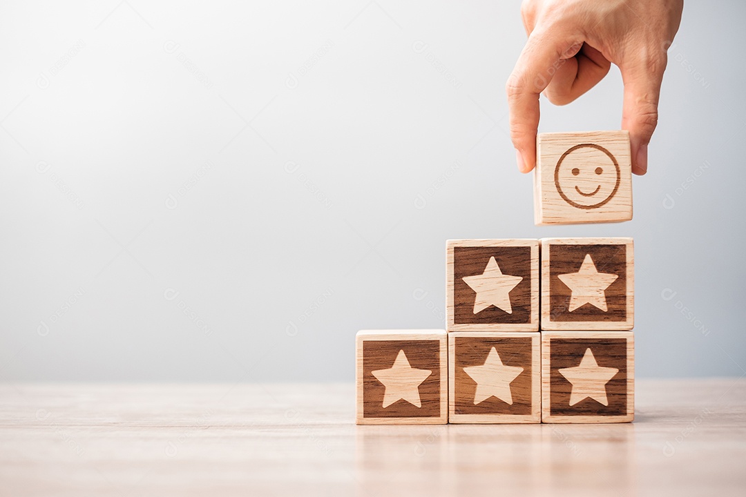 mão segurando o rosto de sorriso sobre blocos de símbolo de estrela na mesa background