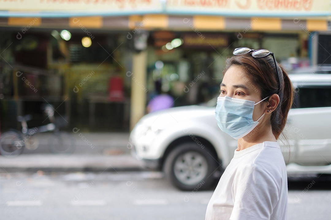 Mulher usando máscara facial médica durante a caminhada na rua