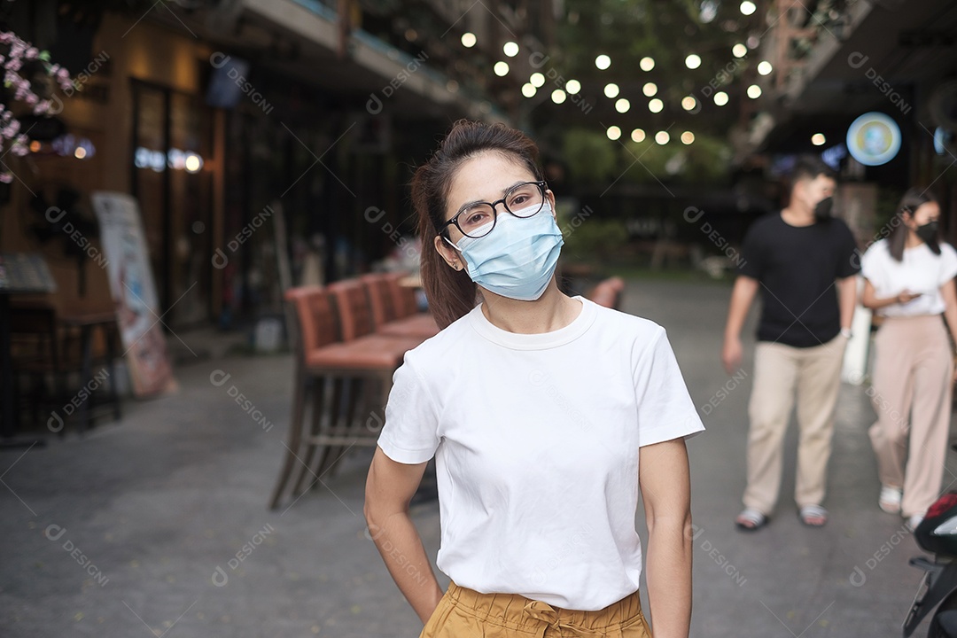 Mulher usando máscara facial médica durante a caminhada na rua