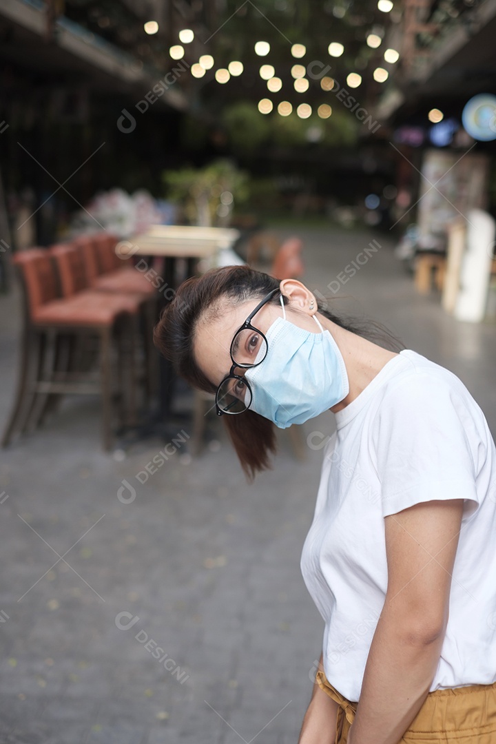 Mulher usando máscara facial médica durante a caminhada na rua
