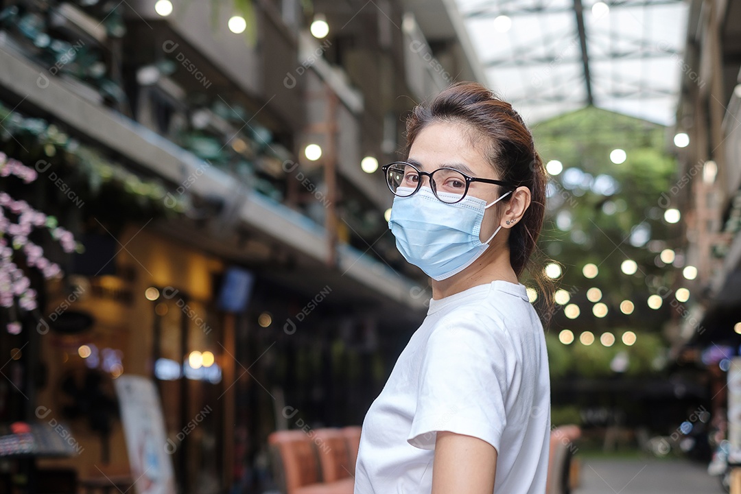 Mulher usando máscara facial médica durante a caminhada na rua