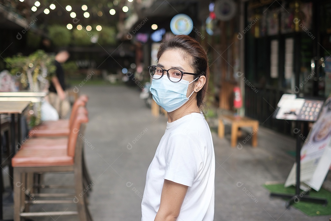 Mulher usando máscara facial médica durante a caminhada na rua