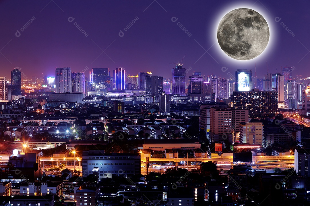 Cidade vista à noite com lua cheia.