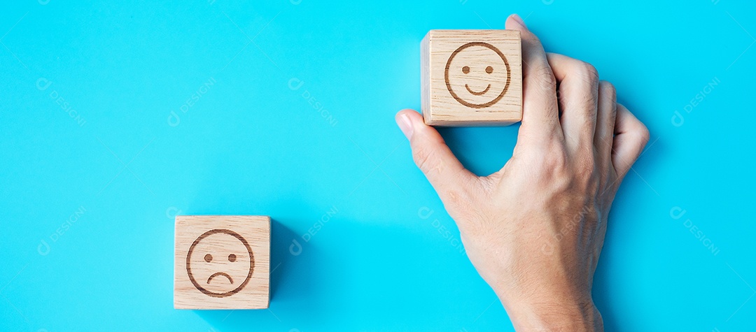 Mão de homem segurando o bloco de rosto de emoção. Cliente escolhe emojis