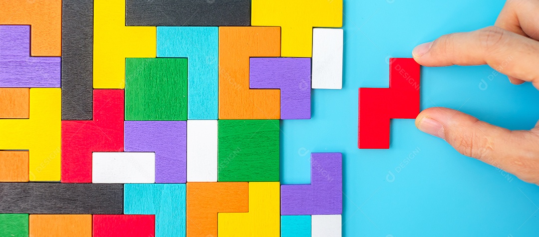 peças de quebra-cabeça de madeira coloridas sobre fundo azul, forma geométrica