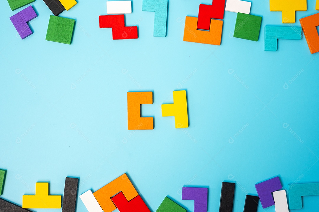 peças de quebra-cabeça de madeira coloridas sobre fundo azul, forma geométrica