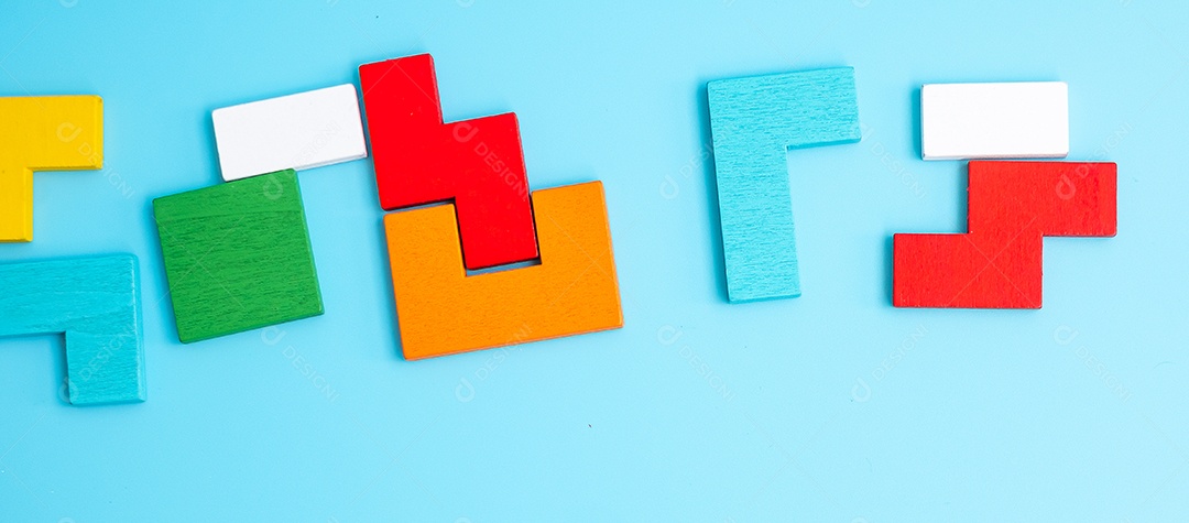 peças de quebra-cabeça de madeira coloridas sobre fundo azul, forma geométrica