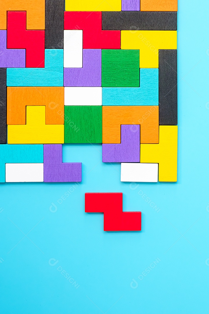 peças de quebra-cabeça de madeira coloridas sobre fundo azul, forma geométrica