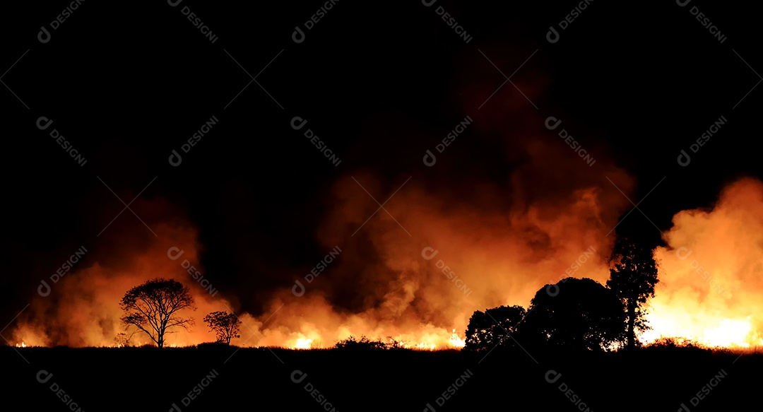 O fogo queimando fumaça laranja e vermelha encheu o céu à noite.