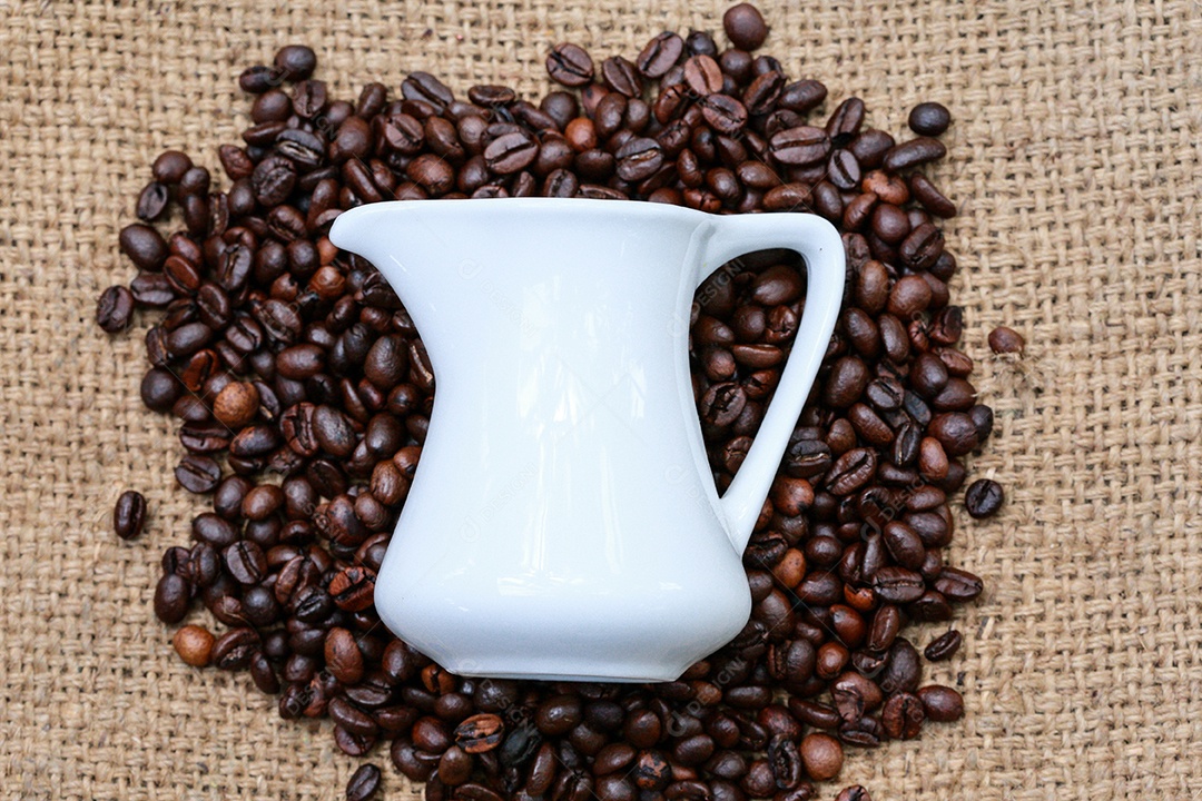 Grãos de café e uma xícara em termos de moda de saco.