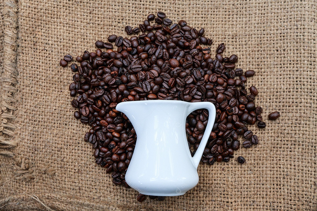 Grãos de café e uma xícara em termos de moda de saco.