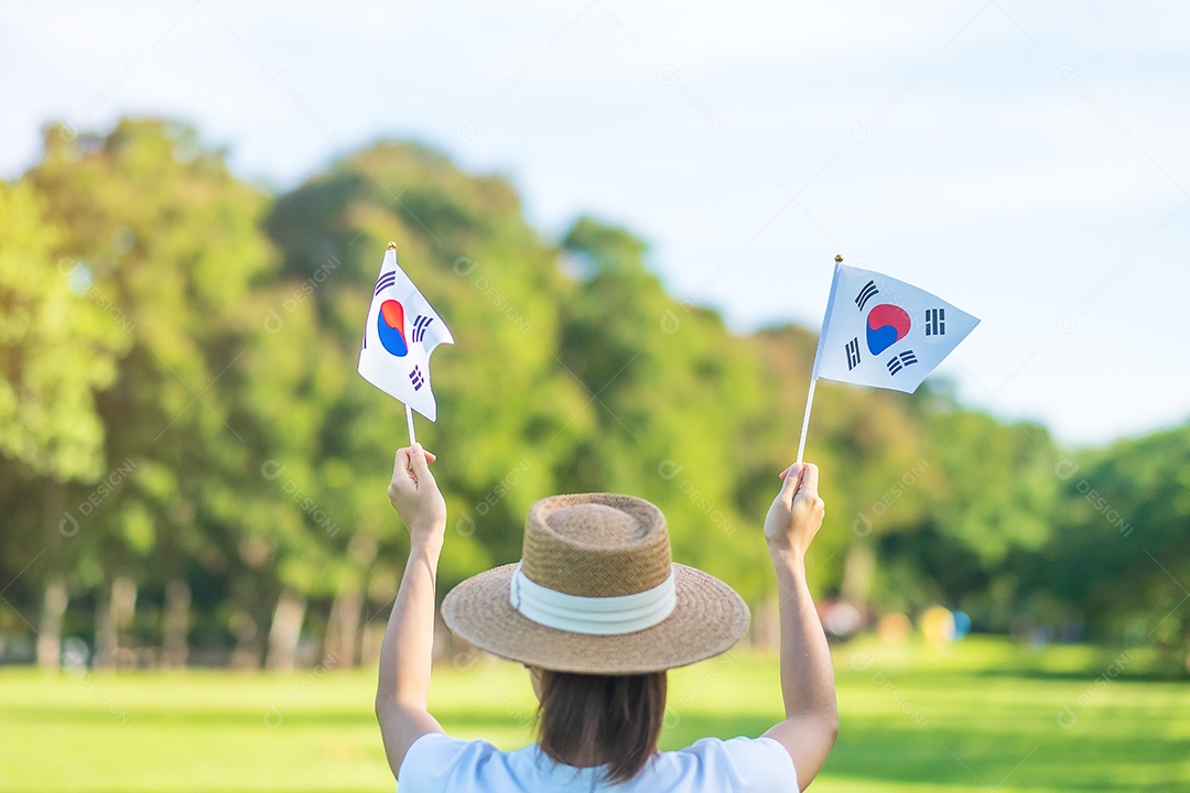 Mão segurando a bandeira da Coreia no fundo da natureza. Fundação Nacional.