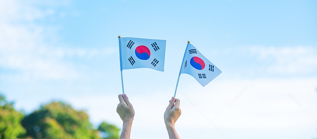 Mão segurando a bandeira da Coreia no fundo da natureza. Fundação Nacional.