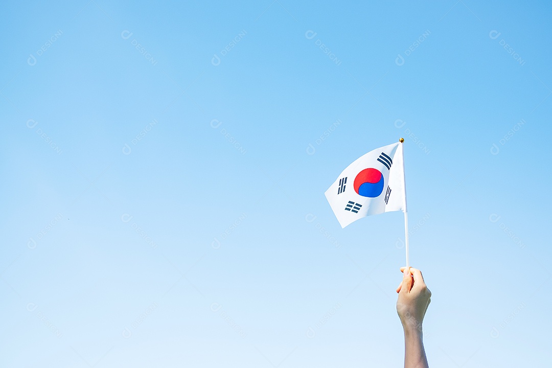 Mão segurando a bandeira da Coreia no fundo da natureza. Fundação Nacional.