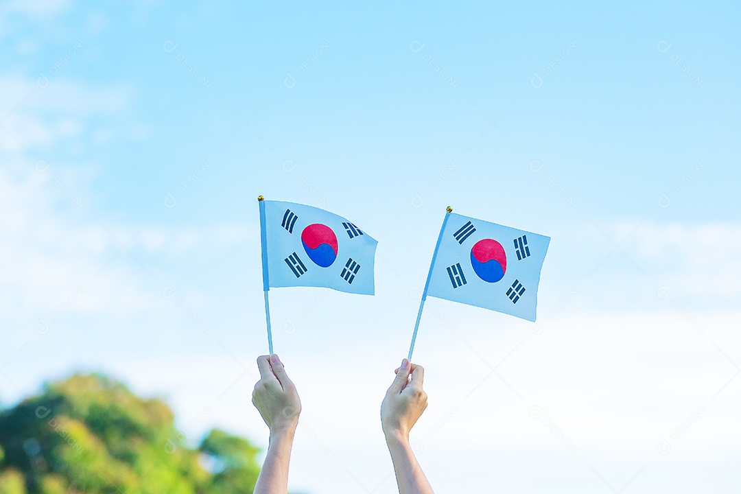 Mão segurando a bandeira da Coreia no fundo da natureza. Fundação Nacional