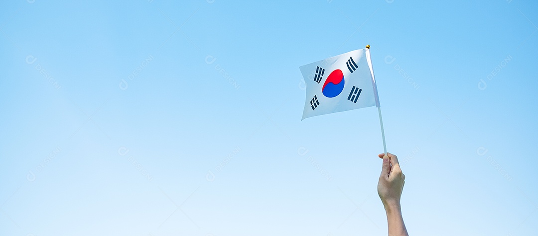 mão segurando a bandeira da Coreia no fundo da natureza. Fundação Nacional