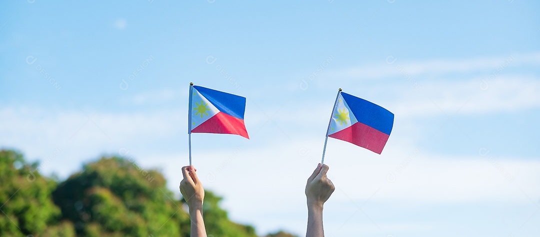 mão segurando a bandeira das Filipinas no fundo da natureza