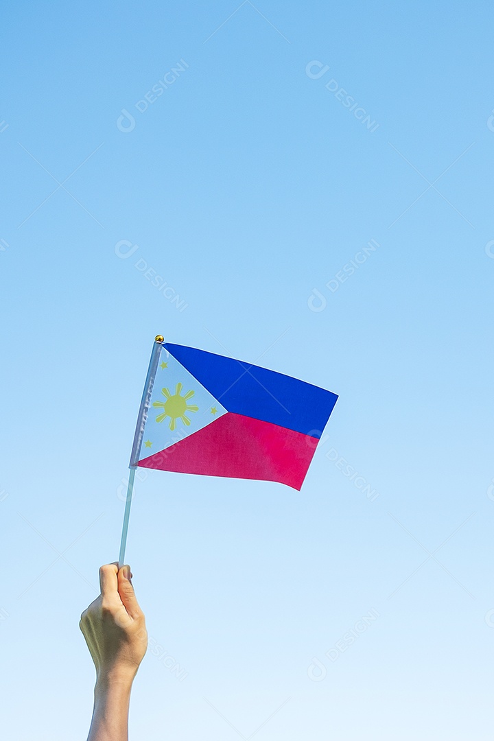 Mão segurando a bandeira das Filipinas no fundo da natureza. 12 de junho.