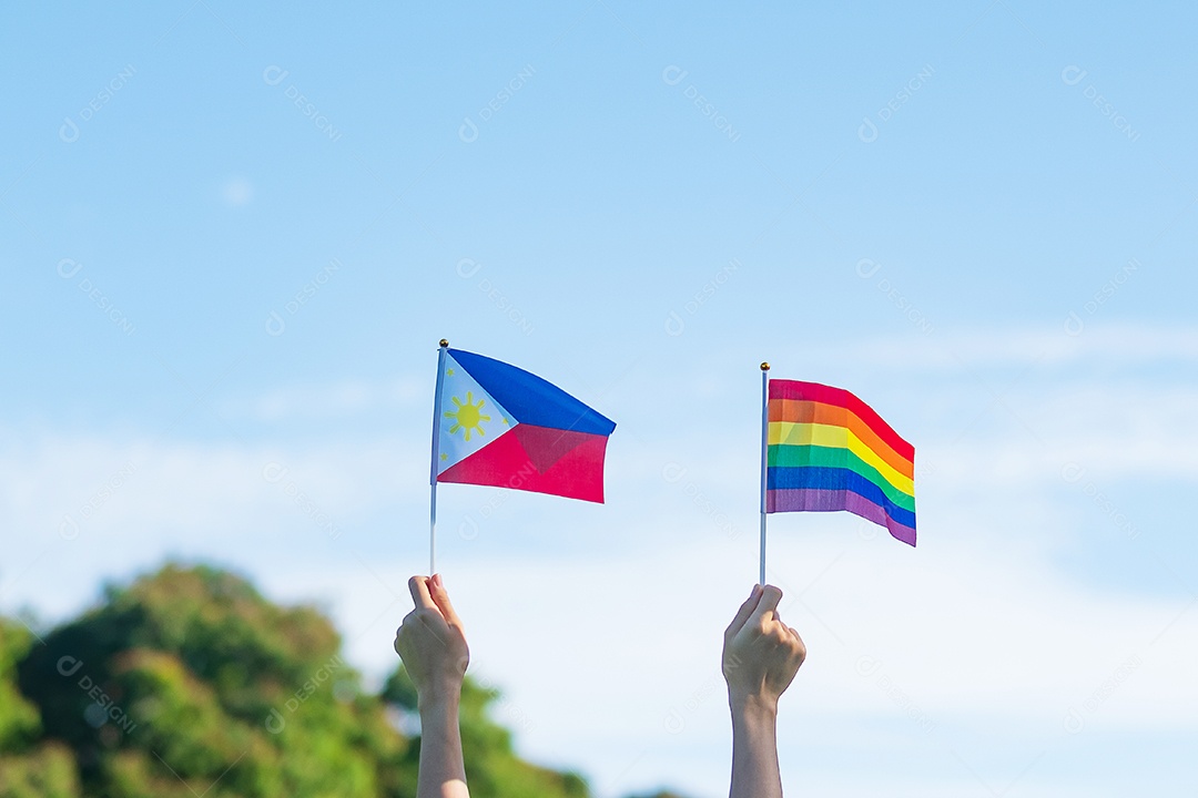 Mãos mostrando LGBTQ Arco-íris e bandeira das Filipinas no fundo da natureza.