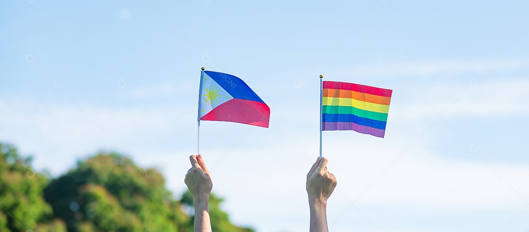 Mãos mostrando LGBTQ Arco-íris e bandeira das Filipinas no fundo da natureza.