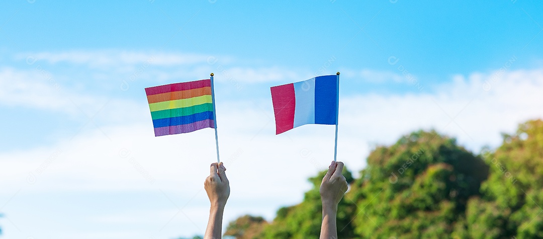 Hands showing LGBTQ Rainbow and flag of France on nature background.