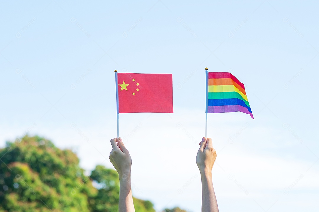 Mãos mostrando LGBTQ  Arco-Íris e bandeira da China no fundo da natureza.