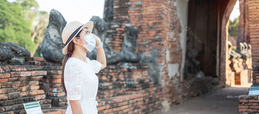 Mulher turista de vestido branco usando máscara cirúrgica