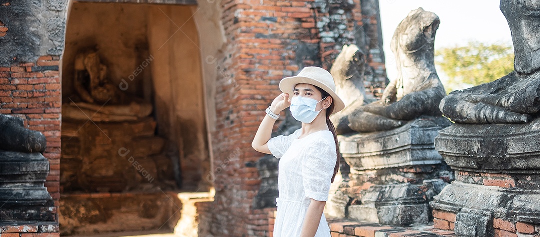 Mulher turista de vestido branco usando máscara cirúrgica
