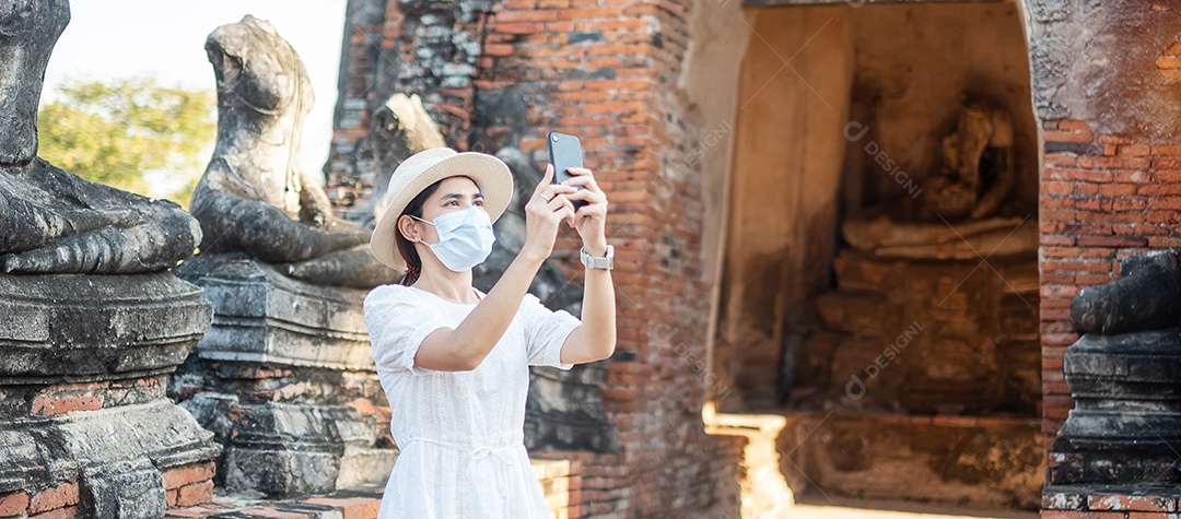 Mulher turista feliz usando máscara cirúrgica e tirando foto