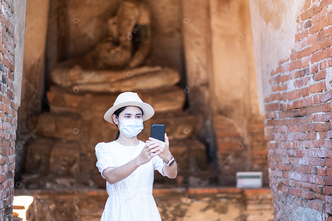 Mulher turista feliz usando máscara cirúrgica e tirando foto