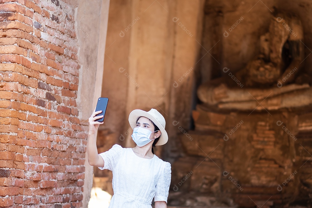 Mulher turista feliz usando máscara cirúrgica e tirando foto