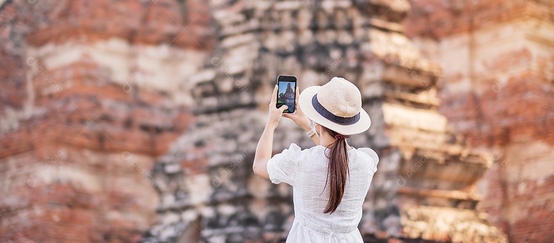 Mulher turista feliz usando máscara cirúrgica e tirando foto