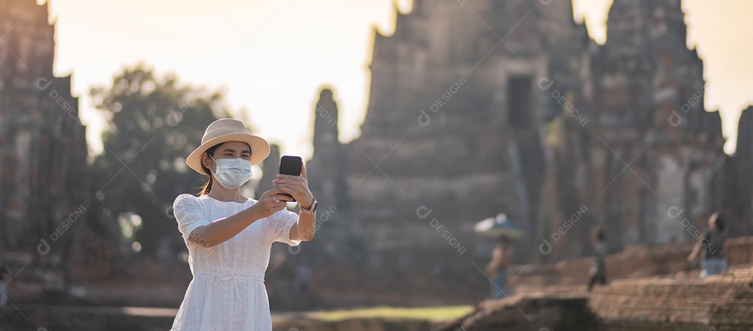 Mulher turista feliz usando máscara cirúrgica e tirando foto