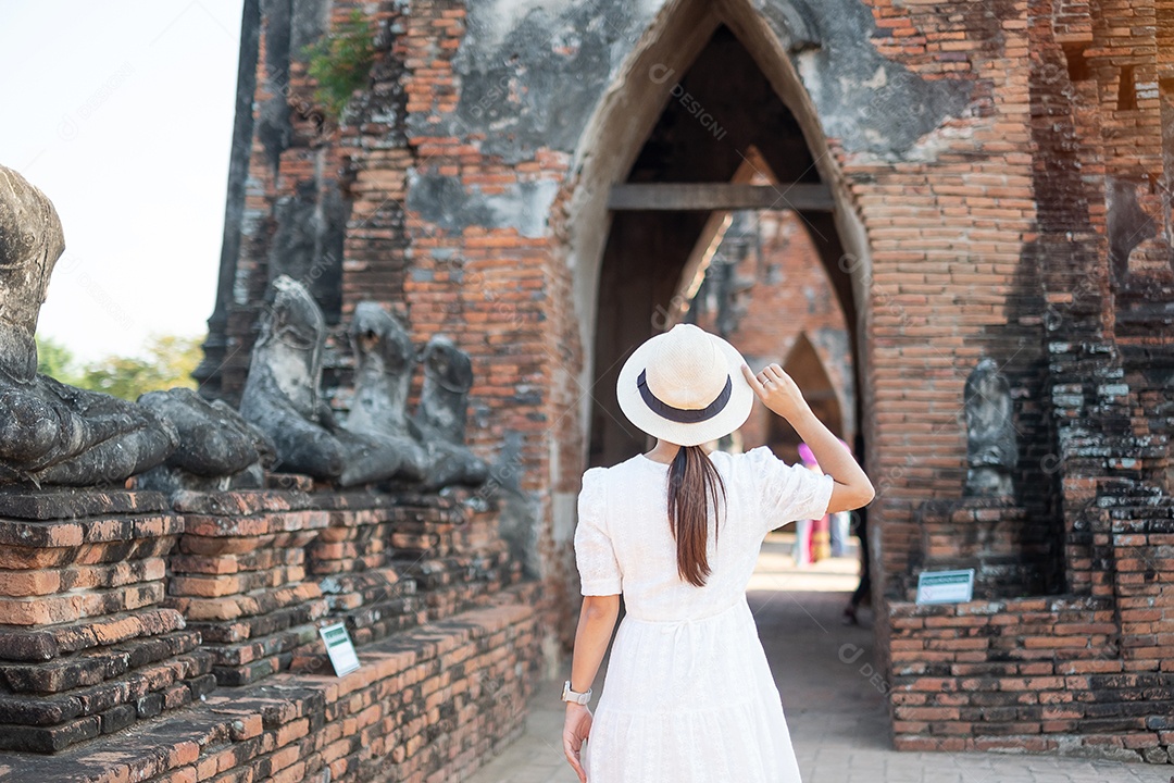 Mulher turista de vestido branco visitando a antiga stupa em Wat Ch