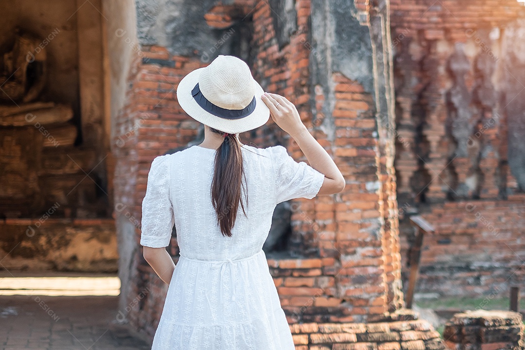Mulher turista de vestido branco visitando a antiga stupa em Wat Ch