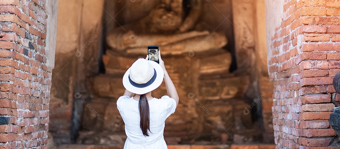 Mulher turista feliz em vestido branco tirando foto pelo smartphone móvel